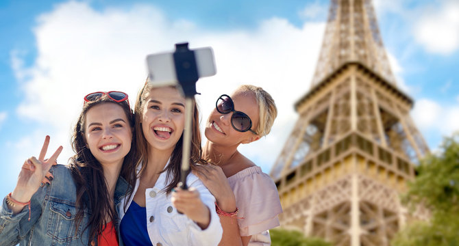 group of smiling women taking selfie in paris