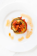 A white plate with ratatouille