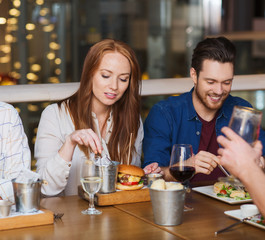 man with smartphone and friends at restaurant