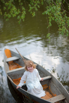 small girl in the boat at the river