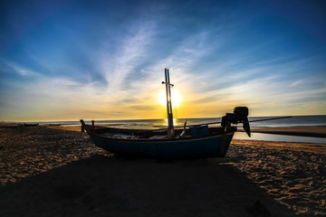 beautiful sunset sunrise background on the beach with silhouette boat in the foreground