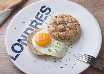 Scrambled eggs sunny side up on bread. Breakfast on a white plate.