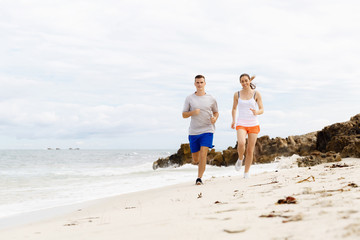 Runners. Young couple running on beach