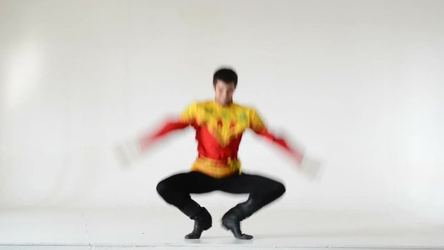 Young man wearing a folk costumes dancing on white in full length.