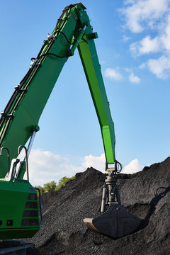 Coal loading excavator, heaps of coal