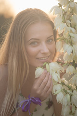 Naklejka premium close-up portrait.. Young beautiful pretty woman posing in long dress against in the field with white flowers