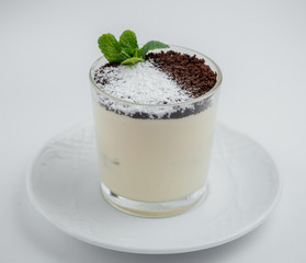 Tiramisu with chocolate chips in a glass on a white saucer
