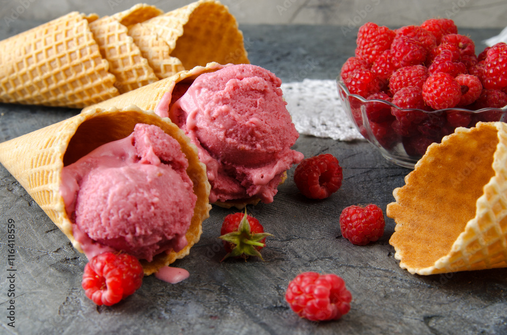 Leinwandbilder raspberry ice cream with ice cream cones on stone table.
