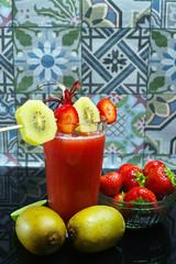 Fresh pressed strawberry and gold kiwi juice in a glass