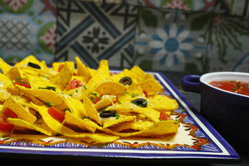 A plate of delicious tortilla nachos with melted cheese sauce