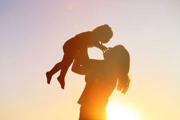 Naklejka premium mother and little daughter play at sunset