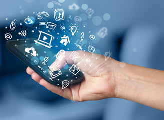 Hand holding smartphone with media icons and symbol