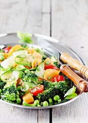 Summer vegetables salad with broccoli,zucchini,carrots,cherry tomatoes and green pea. Clean eating concept.Selective focus