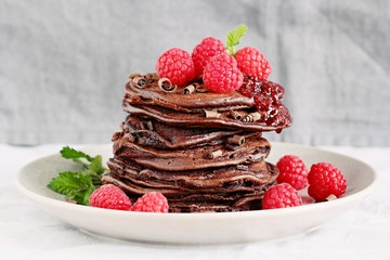 Chocolate pancakes with fresh raspberries. Selective focus