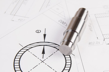Metal cylinders on printed engineering drawings. Mechanics and Engineering Technology. Engineering drawings of steel parts.