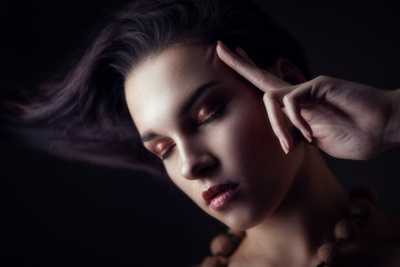 Low key beauty portrait of brunette with closed eyes