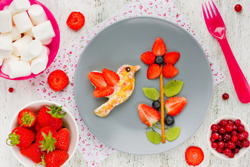 Toast with sugar and berry fruit in the form of a hummingbird on flower