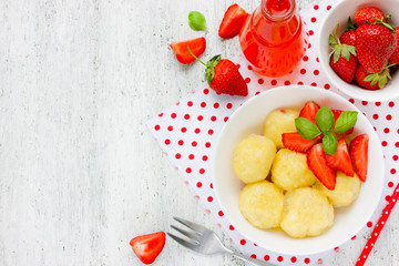 Cottage cheese dumplings with fresh strawberries on white background