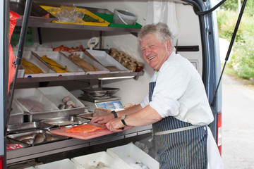 Friendly smiling man serving fresh fish from a mobile van