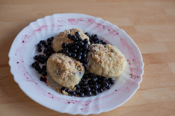 Dumplings with blueberries on white plate