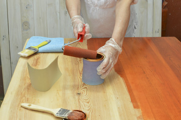 persona que pinta una mesa, con barniz de color cereza