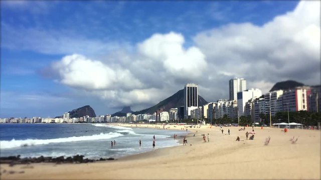 Clouds build over a scenic time lapse view of Copacabana Beach shore from the Leme end with the city skyline of Rio de Janeiro, Brazil
