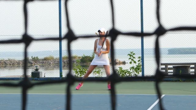 Girl play tennis outdoor on tennis court. Dolly