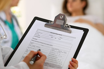Close-up of a female doctor while filling up medical history record