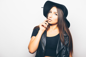 beautiful fashion girl wearing sunglasses and black hat over a white background.