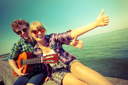 Young man hipster with guitar and woman.