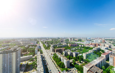 Aerial city view with crossroads and roads, houses, buildings, parks and parking lots, bridges. Urban landscape. Copter shot. Panoramic image.