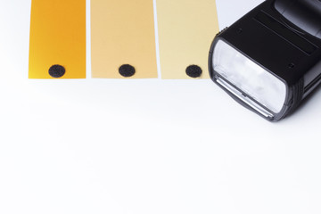 Head of a camera flash, over a white background with the orange gels for a color temperature orange...