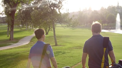 Slow Motion Shot Of Male Golfers Walking Along Fairway