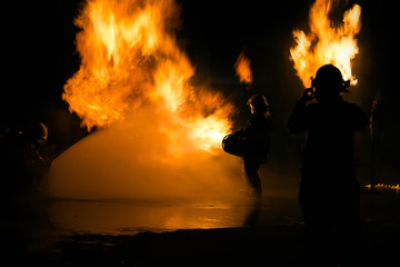 Fototapeta na wymiar Man in fire show after Firefighters training, Rehearse of firefighters from cooking.