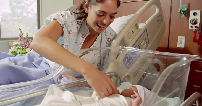 Mother With Newborn Baby In Hospital Bed 