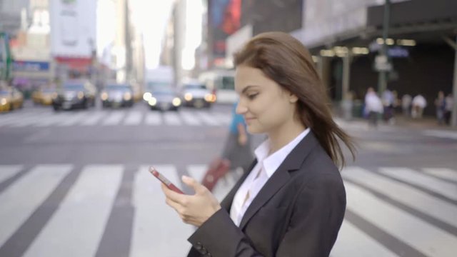 attractive business women using smart phone in the city commuting to work