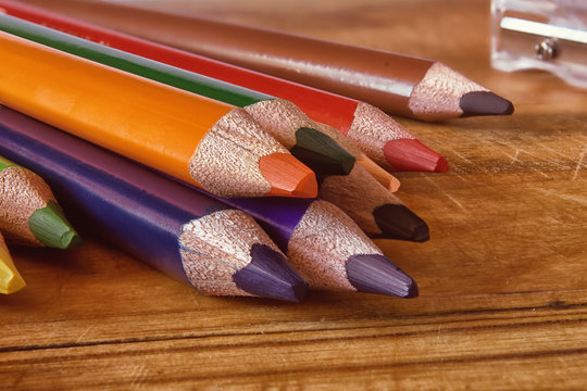 Colored pencils on a wooden surface.