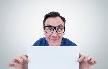 Happy man in glasses holds a sheet in front of white paper