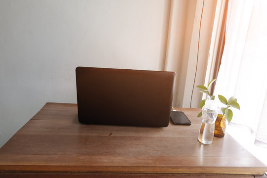 laptop with mobile phone  on wooden  table on coffee cafe