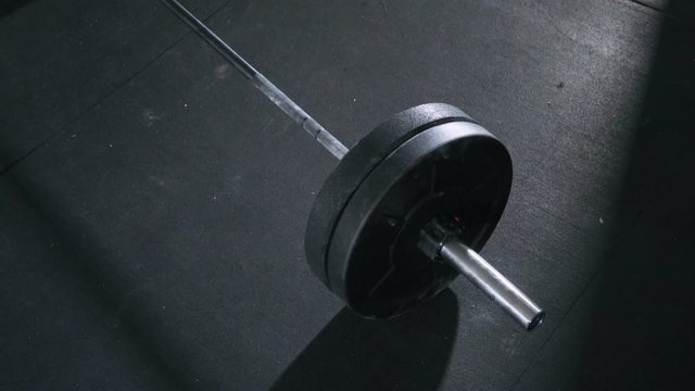Closeup of barbell lying on gym floor ready for deadlift