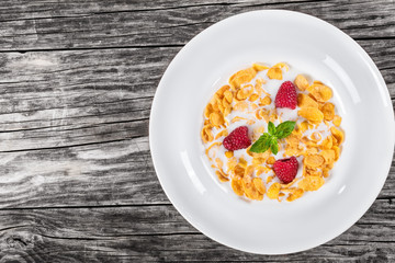 corn flakes with raspberry and cold milk, top view