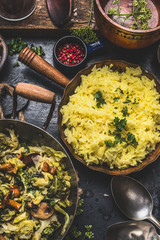 Yellow rice dish  with stewed chopped cabbage and mushrooms on rustic kitchen background, top view. Vegan and Vegetarian cooking .