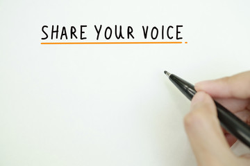 hand writing share your voice  text on paper  , business idea ,