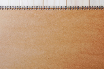 Empty blank brown front page cover of spiral bound notepad on the wooden background