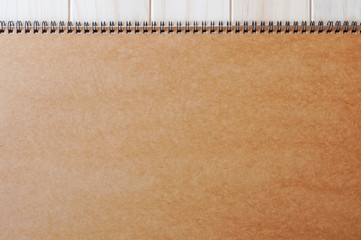 Obraz premium Empty blank brown front page cover of spiral bound notepad on the wooden background