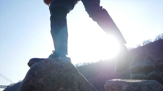 feet walking over stone rocks overcoming obstacles shot in slow motion
