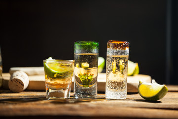 Shot glass of tequila on wood table. Selective focus. Blurred background.