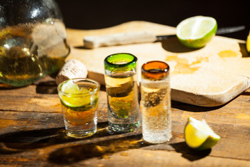 Shot glass of tequila on wood table. Selective focus. Blurred background.