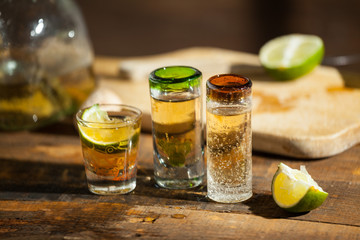 Shot glass of tequila on wood table. Selective focus. Blurred background.