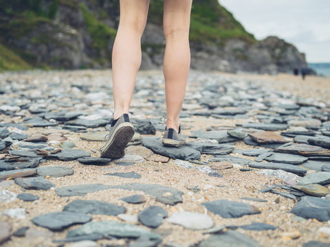 Legs and feet of woman walking on beach